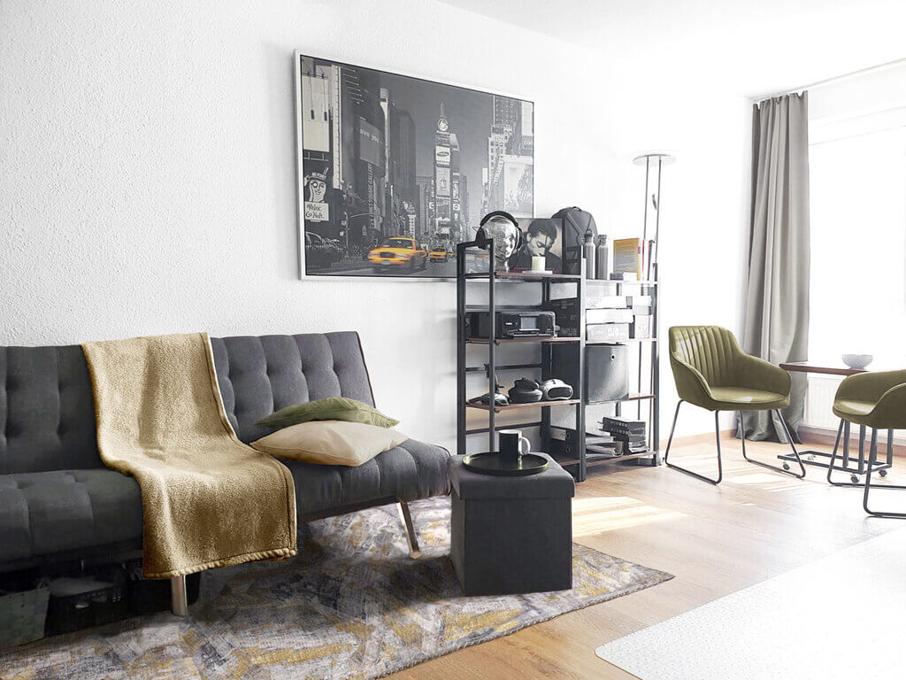 Industrial Raumkonzept mit grauem Sofa, Holzelementen, Metallmöbeln und Akzentfarben in Gelbbraun und Grün.
